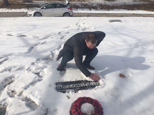 Royal Air Force Master Aircrew Keith Wing, 56 Squadron Rivet Joint specialist, clears snow from the grave of  U.S. Army 1st Lt. Jarvis Offutt February 2018, at Forrest Lawn Memorial Park, Nebraska.