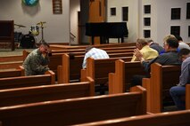 U.S. Air Force Lt. Col. Robert Borger, 17th Training Wing chaplain, kneels for an open prayer session during Clergy Day at the Taylor Chapel on Goodfellow Air Force Base, Texas, May 24, 2018. Borger gathered 25 local pastors to teach them about Goodfellow, its mission and its service members. (U.S. Air Force photo by Staff Sgt. Joshua Edwards/Released)