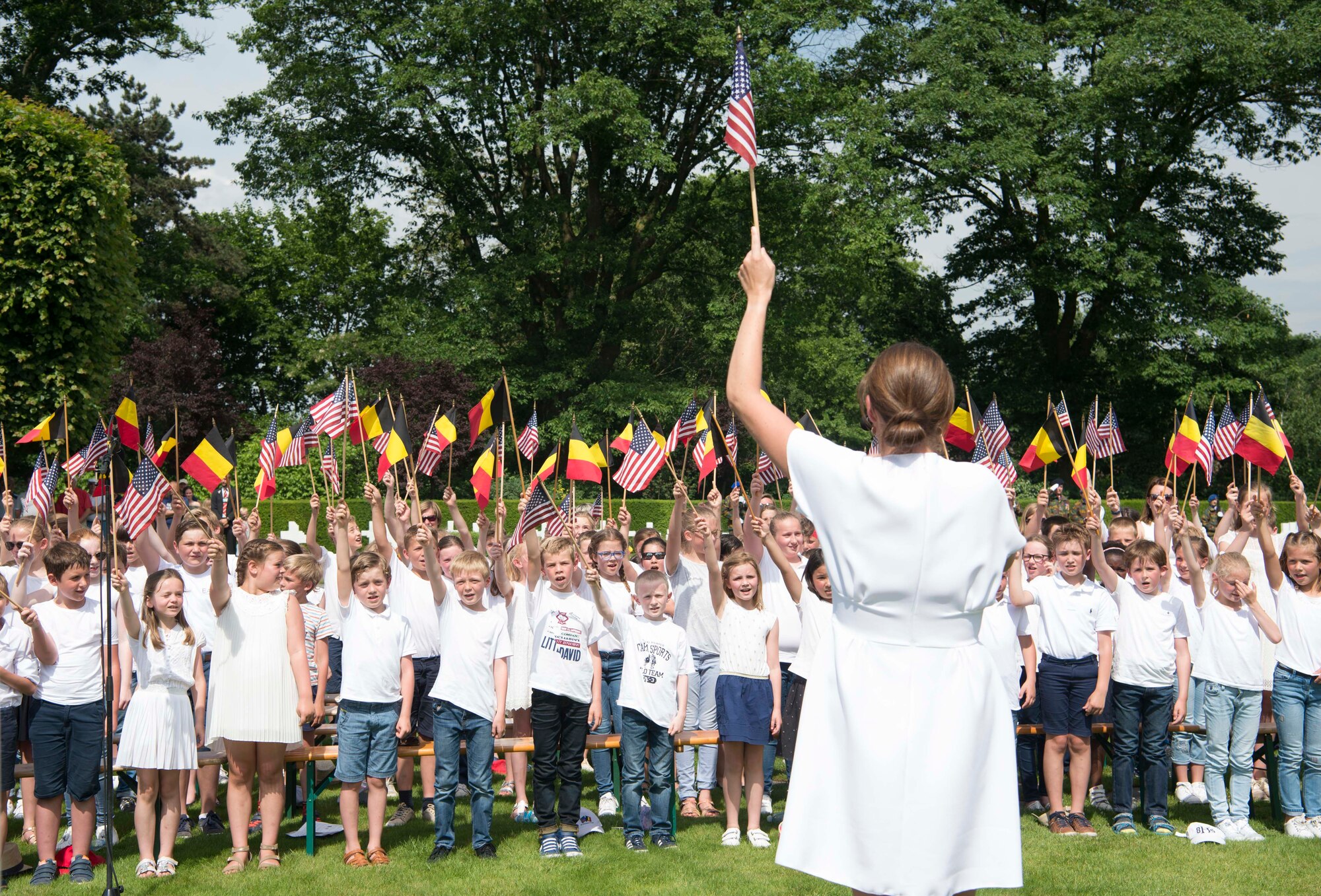 School children from the city of Waregem, sing the Star Spangled Banner at Flanders Field American Cemetery, Belgium, May 27, 2018. School children have sung the U.S. and Belgian national anthems at Flanders Field on Memorial Day every year since 1923. (U.S. Air Force photo by Senior Airman Elizabeth Baker)