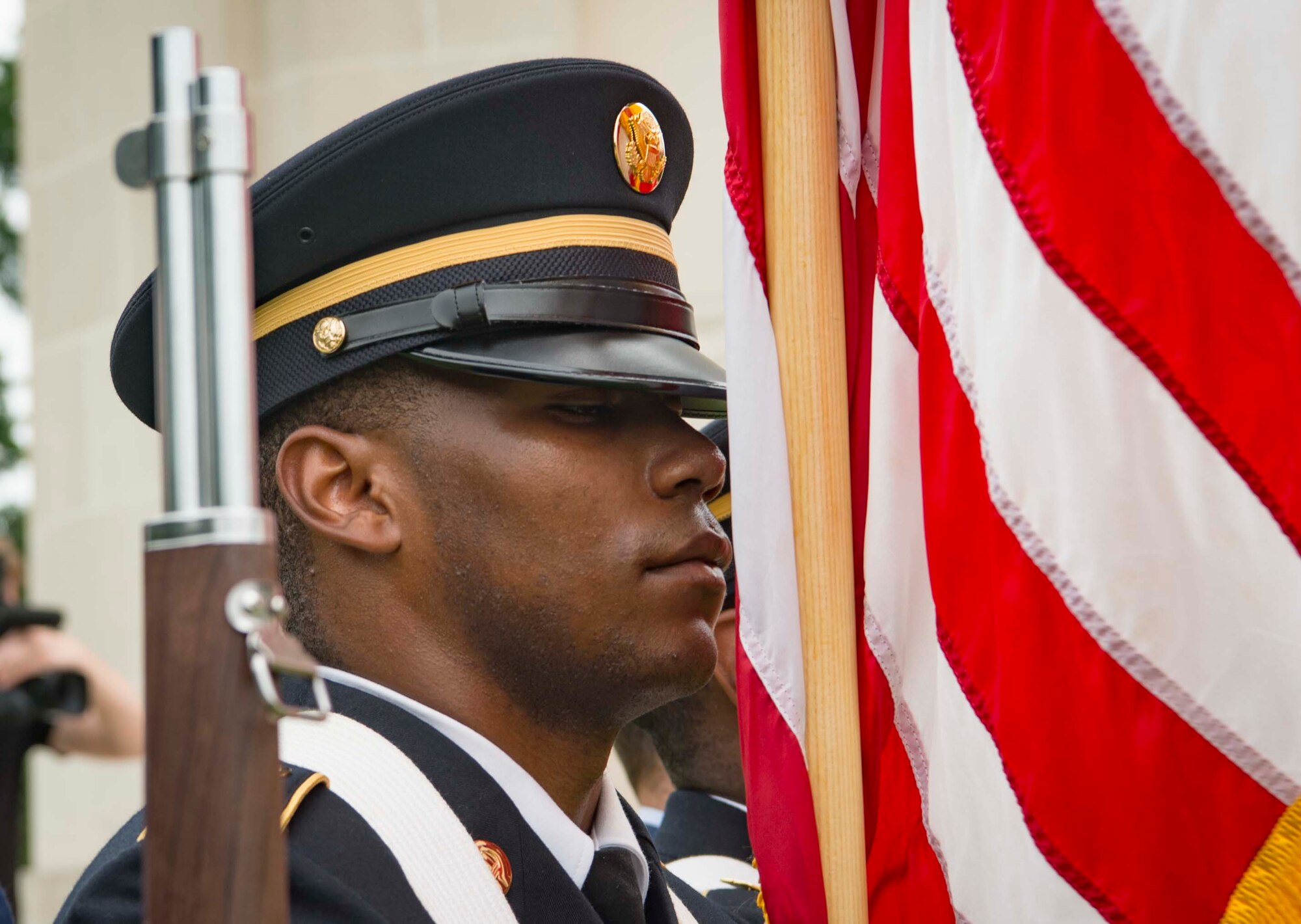 A U.S. Soldier holds the American flag at attention during a Memorial Day ceremony at Flanders Field American Cemetery, Belgium, May 27, 2018. The American Battle Monuments Commission has held Memorial Day ceremonies at Flanders Field since the 1920s, as well as at battle monuments across the world. (U.S. Air Force photo by Senior Airman Elizabeth Baker)