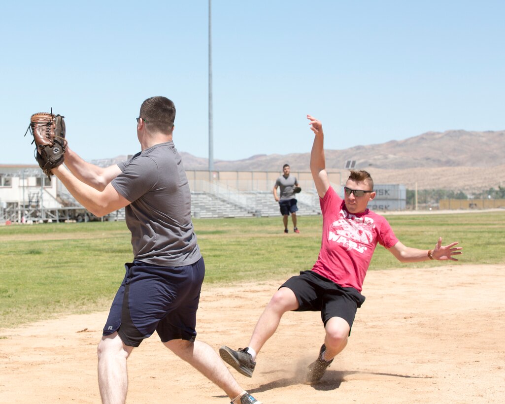 Lance Corporal Tristian Butler, postal clerk, quickly snatches a ball toward third base to beat PFC Collin SanFelice during a softball game held on Sorenson Field aboard Marine Corps Logistics Base Barstow, Calif., May 25. Butler was able to tag SanFelice before he reached the base.