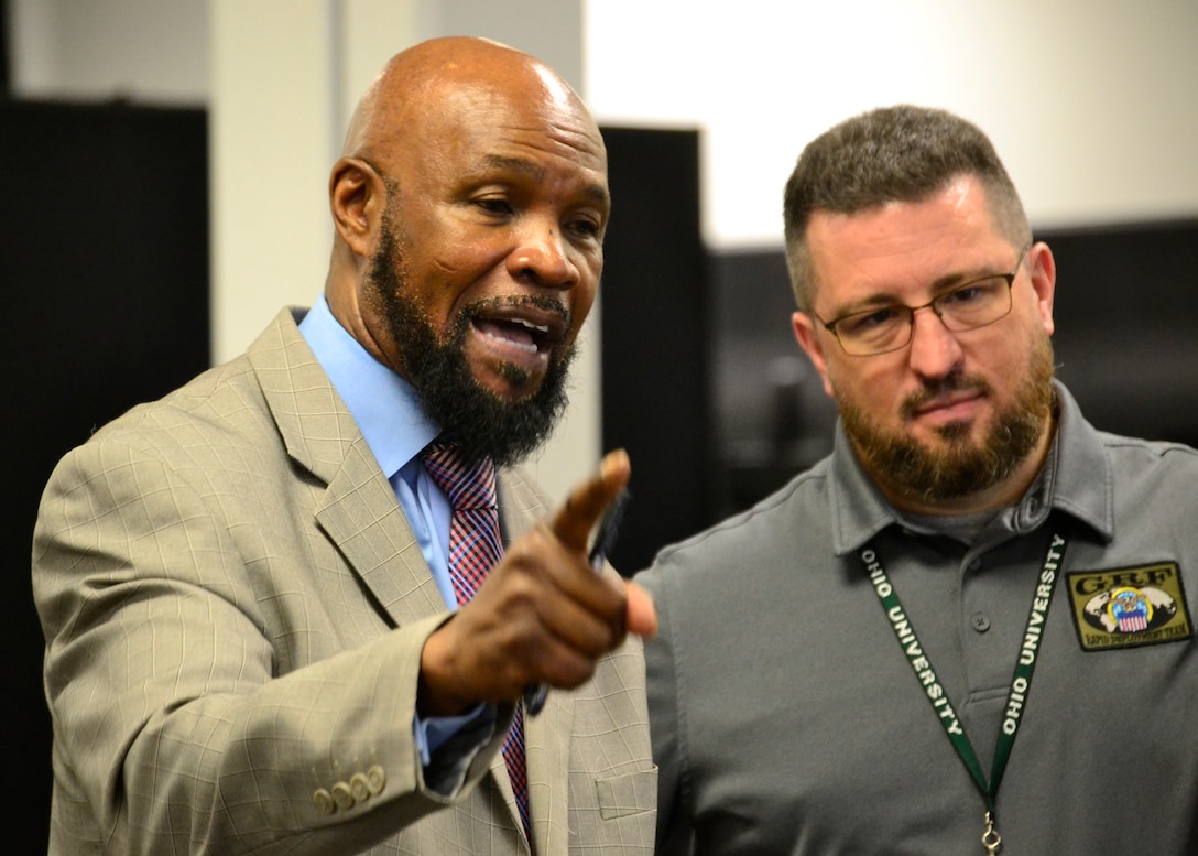 DLA Rapid Deployment Team Red Team deputy commander Archie Turner (left) and RDT Red Team operations officer Taylor Frazier III address DLA Troop Support employees during a humanitarian relief and disaster recovery tabletop exercise May 22 in Philadelphia.