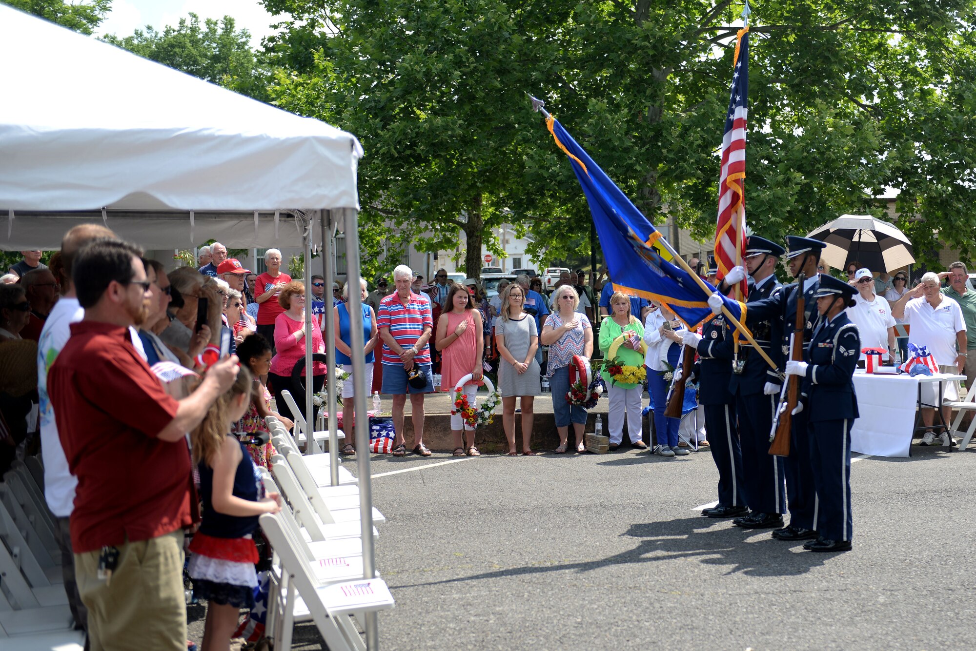 Four honor guardsmen present the colors to a crowd.