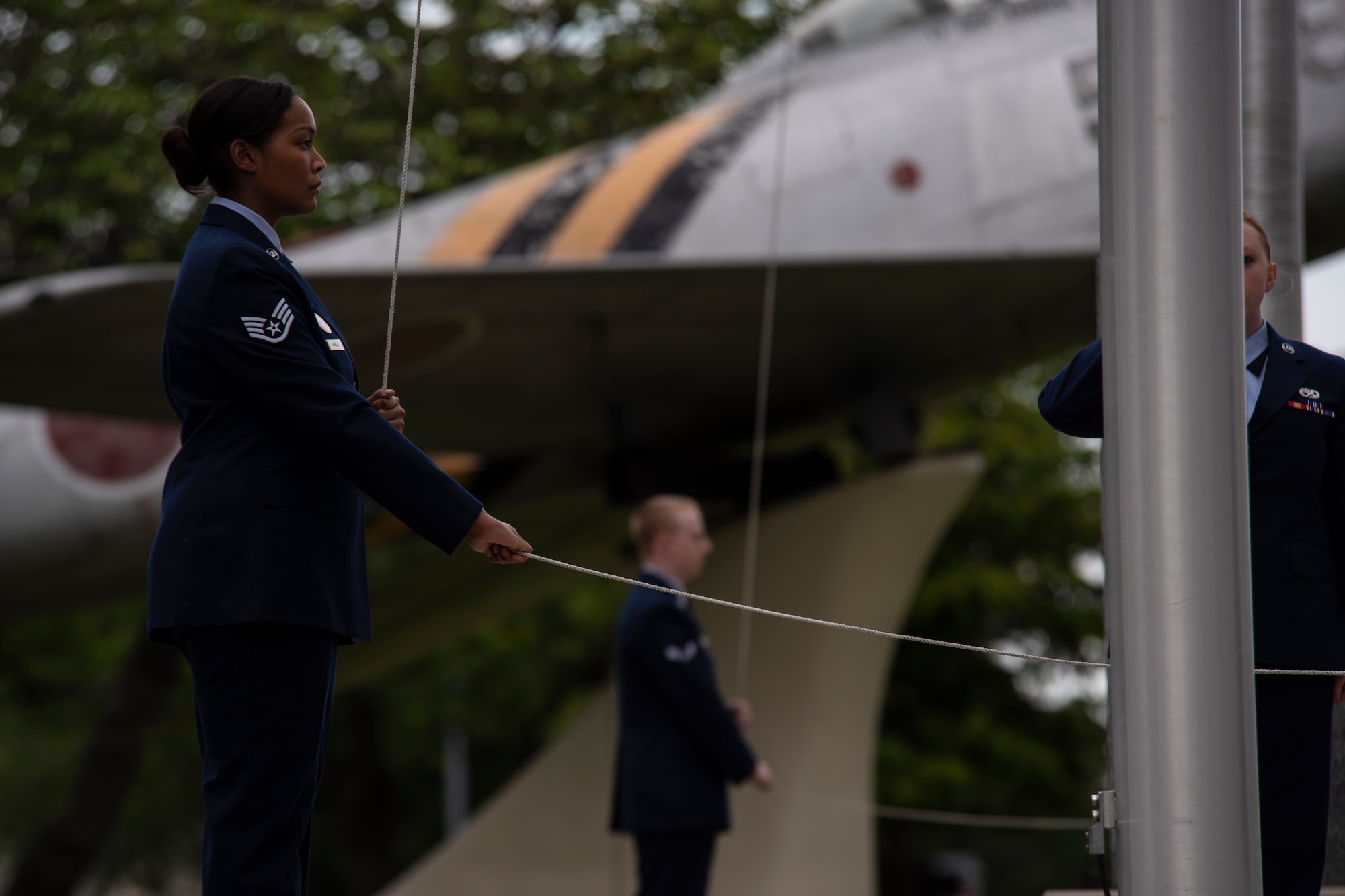 U.S. Air Force Staff Sgt. Jalessa Randle, the 35th Force Support Squadron commander executive assistant, lowers the American flag during a Memorial Day ceremony at Misawa Air Base, Japan, May 25, 2018. Six Airmen with the 35th Fighter Wing served as ceremonial caretakers of the U.S. and Japan flags during the ceremony. (U.S. Air Force photo by Airman 1st Class Collette Brooks)
