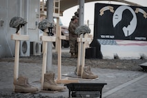 Helmets, boots and crosses sit in front of the 380th Air Expeditionary Wing headquarters for Memorial Day as a reminder of all the service members who gave their lives in the line of duty, May 28, 2018. (U.S. Air Force photo by Staff Sgt. Erica Rodriguez)