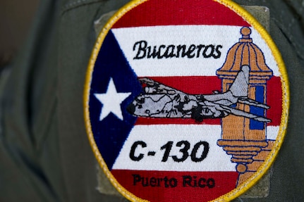 An Airman assigned to the 156th Airlift Wing wears the unit’s patch at Muniz Air National Guard Base, Puerto Rico May 29, 2018. Unit members continue their mission despite facing incredible challenges from Hurricane Maria to losing nine Airmen in a WC-130 crash.