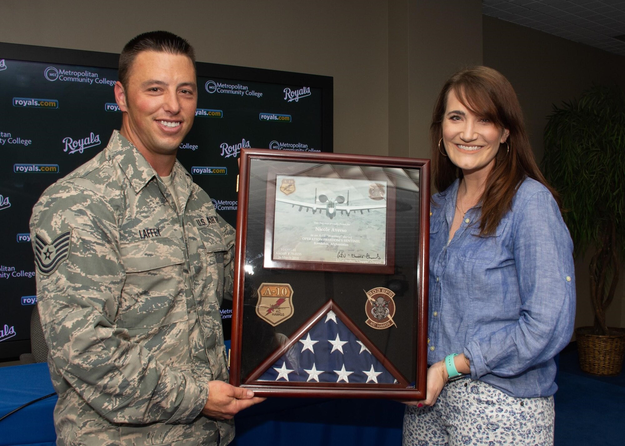 U.S. Air Force Tech. Sgt. Sean Laffey, armament specialist, assigned to the 442d Maintenance Squadron presents a U.S. flag to Nicole Averso, the Kansas City Royals manager of event presentations, prior to the opening pitch at Kauffman Stadium, Kansas City, Mo., May 19, 2018.