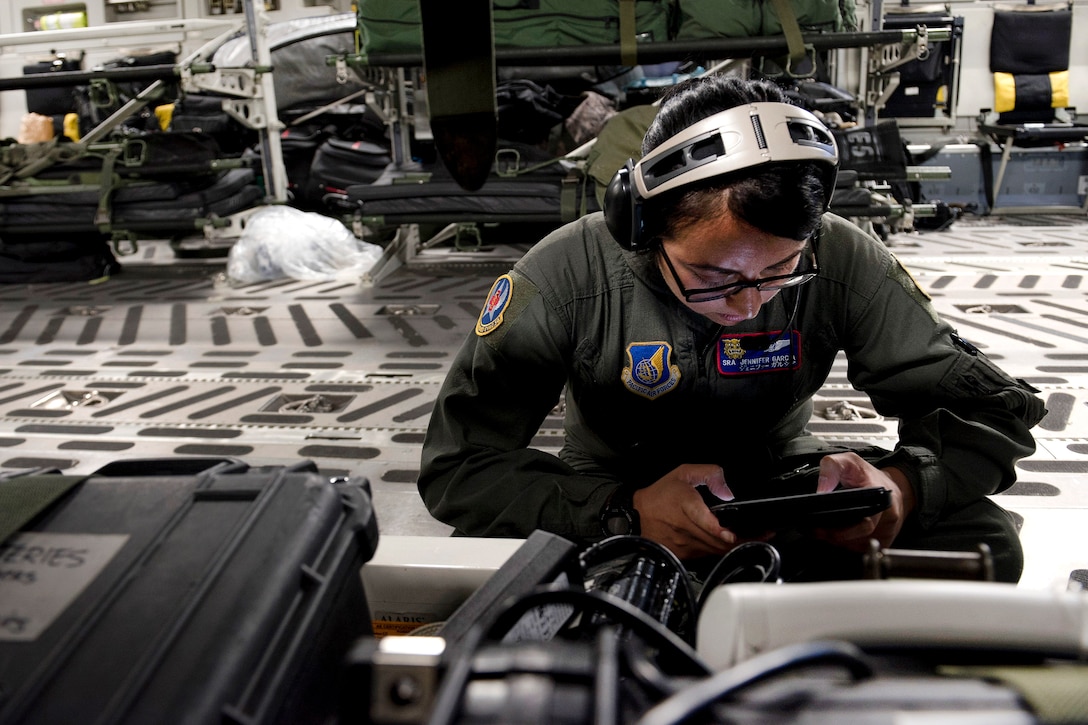 : An airman reviews operational checklists of medical equipment.