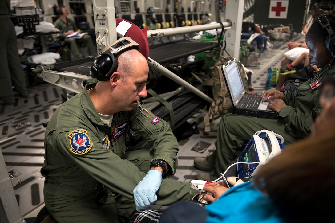 An airman checks the vitals of a patient.