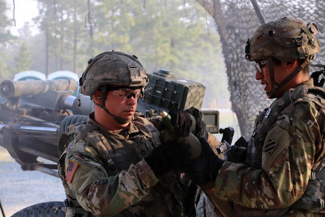 Soldiers prepare a howitzer ammo round.