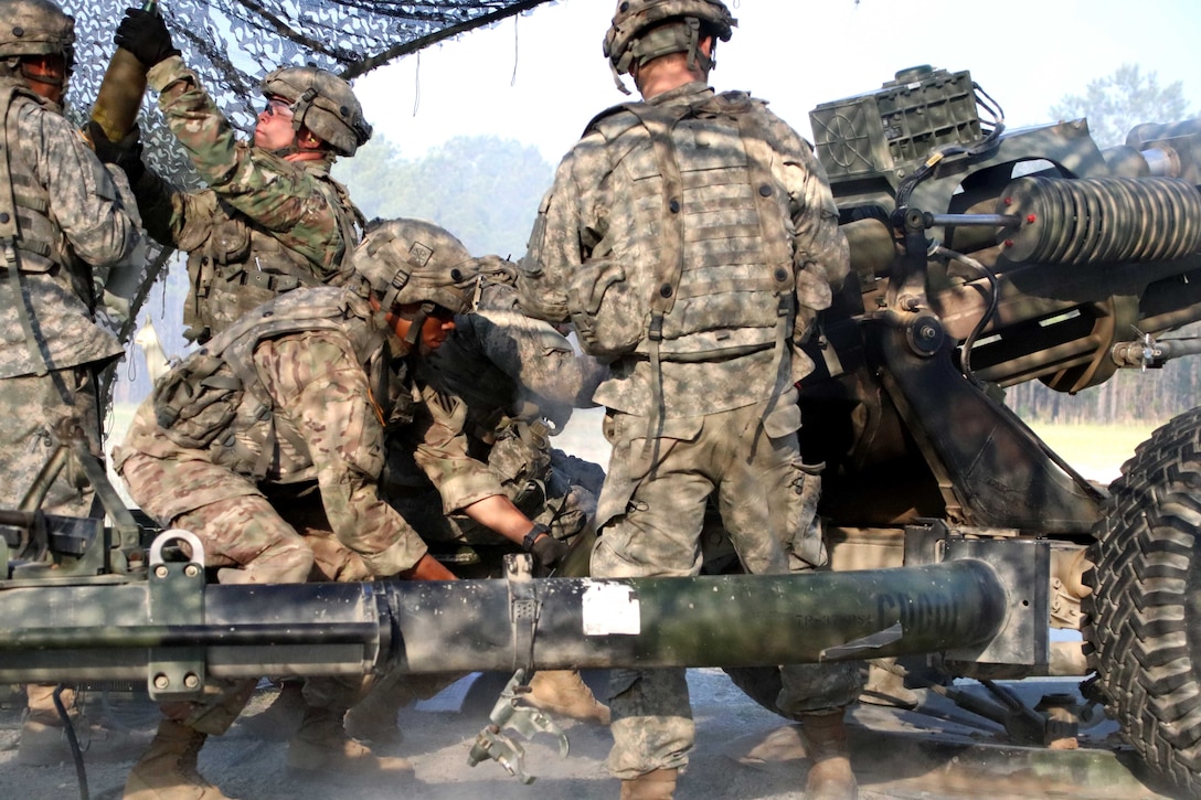 Soldiers prepare a howitzer ammo round.