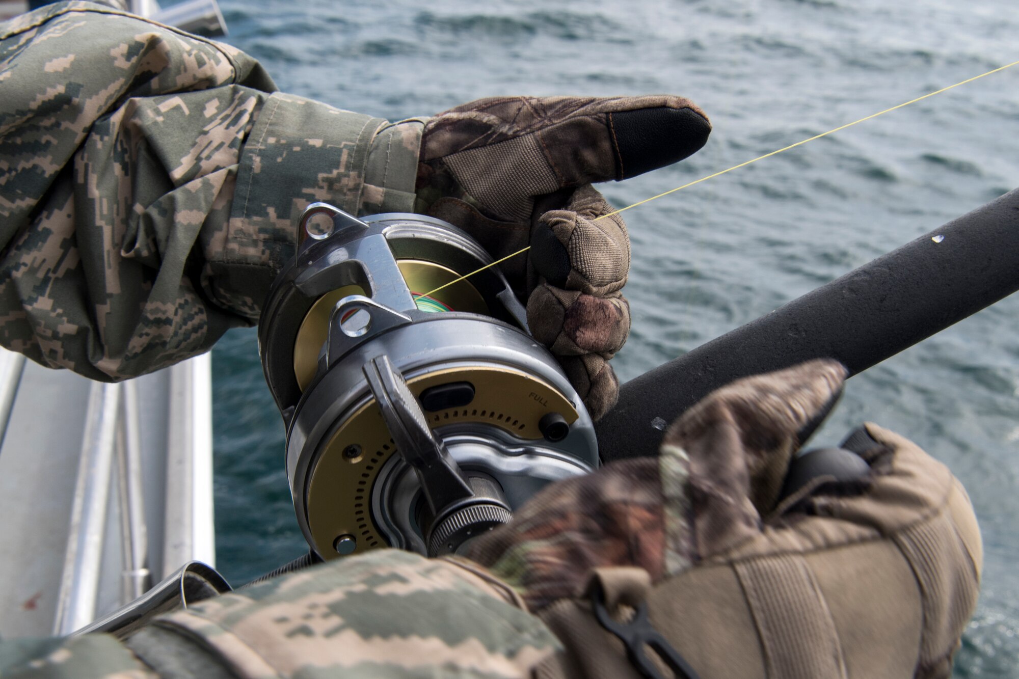 Air Force Staff Sgt. Lyndeana Parsons, a 3rd Maintenance Squadron F-22 Raptor dedicated crew chief, reels in a fishing line to check bait during the Armed Services YMCA of Alaska Combat Fishing Tournament in Seward, Alaska, May 24, 2018. Parsons was assigned to Puffin Fishing Charter, ‘Tenacious,’ one of 23 charter vessels participating in this year’s tournament. The fishing tournament was open to service members in grades E1 to E5, who are considered active duty and permanently stationed in Alaska.