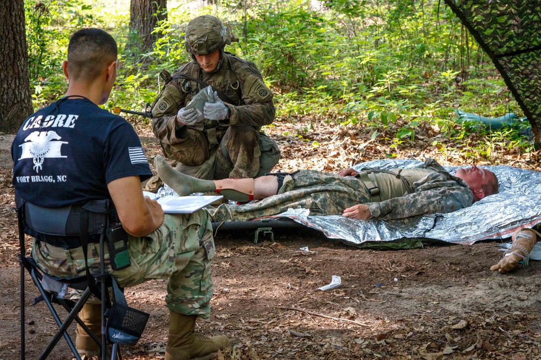 A soldier provides field medical aid to a role-playing casualty.