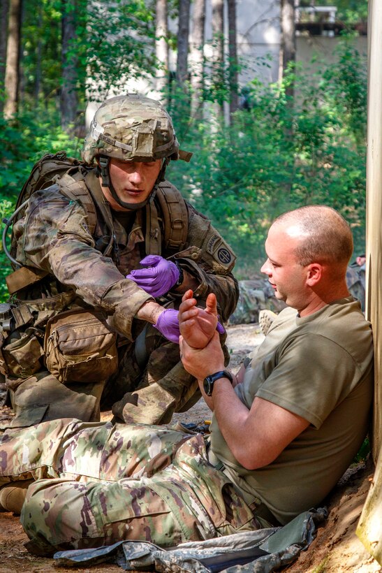 A soldier provides field medical aid to a role-playing casualty.