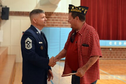 A member of Sons of the American Legion Post 158 greets U.S. Air Force Chief Master Sgt. Patrick McMahon, U.S. Strategic Command senior enlisted leader, during a Memorial Day ceremony at Cedar Bluff Auditorium in Cedar Bluff, Neb., May 28, 2018.