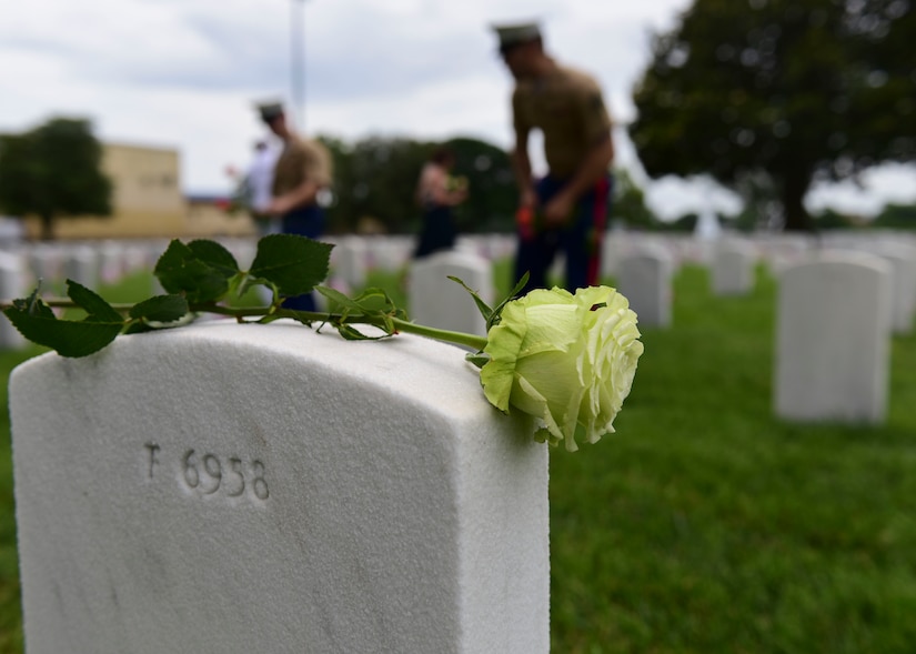 U.S. Marines place flowers on gravesites of fallen service members during a Memorial Day wreath-laying ceremony at Hampton National Cemetery in Hampton, Virginia, May 28, 2018. Attendees placed hundreds of flowers on gravesites throughout the cemetery to reflect on fallen service members’ sacrifices.  (U.S. Air Force photo by Airman 1st Class Monica Roybal)