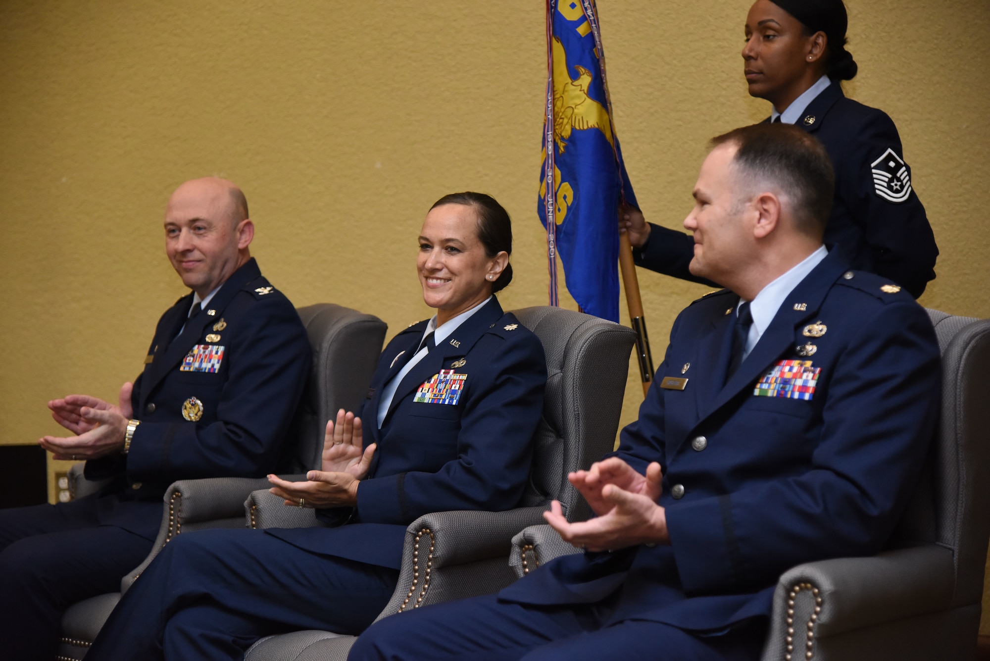 U.S. Air Force Col. Danny Davis, 81st Mission Support Group commander, Lt. Col. Melissa Rativa, 81st Logistics Readiness Squadron outgoing commander, and Maj. Matthew Roberts, incoming 81st LRS commander, applaud during the 81st LRS change of command ceremony in the Bay Breeze Event Center at Keesler Air Force Base, Mississippi, May 23, 2018. The ceremony is a symbol of command being exchanged from one commander to the next by the hand off of a ceremonial guidon. Davis passed on command of the 81st LRS to Roberts. (U.S. Air Force photo by Kemberly Groue)