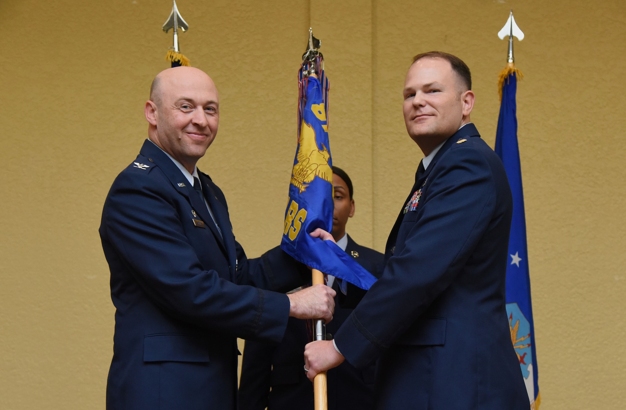 U.S. Air Force Col. Danny Davis, 81st Mission Support Group commander, passes command of the 81st Logistics Readiness Squadron to Maj. Matthew Roberts, 81st LRS commander, during the 81st LRS change of command ceremony in the Bay Breeze Event Center at Keesler Air Force Base, Mississippi, May 23, 2018. The ceremony is a symbol of command being exchanged from one commander to the next by the hand off of a ceremonial guidon. (U.S. Air Force photo by Kemberly Groue)