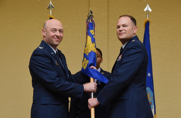 U.S. Air Force Col. Danny Davis, 81st Mission Support Group commander, passes command of the 81st Logistics Readiness Squadron to Maj. Matthew Roberts, 81st LRS commander, during the 81st LRS change of command ceremony in the Bay Breeze Event Center at Keesler Air Force Base, Mississippi, May 23, 2018. The ceremony is a symbol of command being exchanged from one commander to the next by the hand off of a ceremonial guidon. (U.S. Air Force photo by Kemberly Groue)