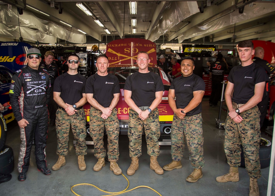 U.S. Marines with 6th Marine Corps District pose for a group photo with Spencer Boyd, the driver of the Grunt Style stock car, during the Coca-Cola 600 at the Charlotte Motor Speedway on May 24, 2018. The Marines took part in the battles won challenge trailer at the Coca-Cola 600 NASCAR race to spread awareness of the opportunities that the Marine Corps can provide. (U.S. Marine Corps photo by Lance Cpl. Jack A. E. Rigsby)