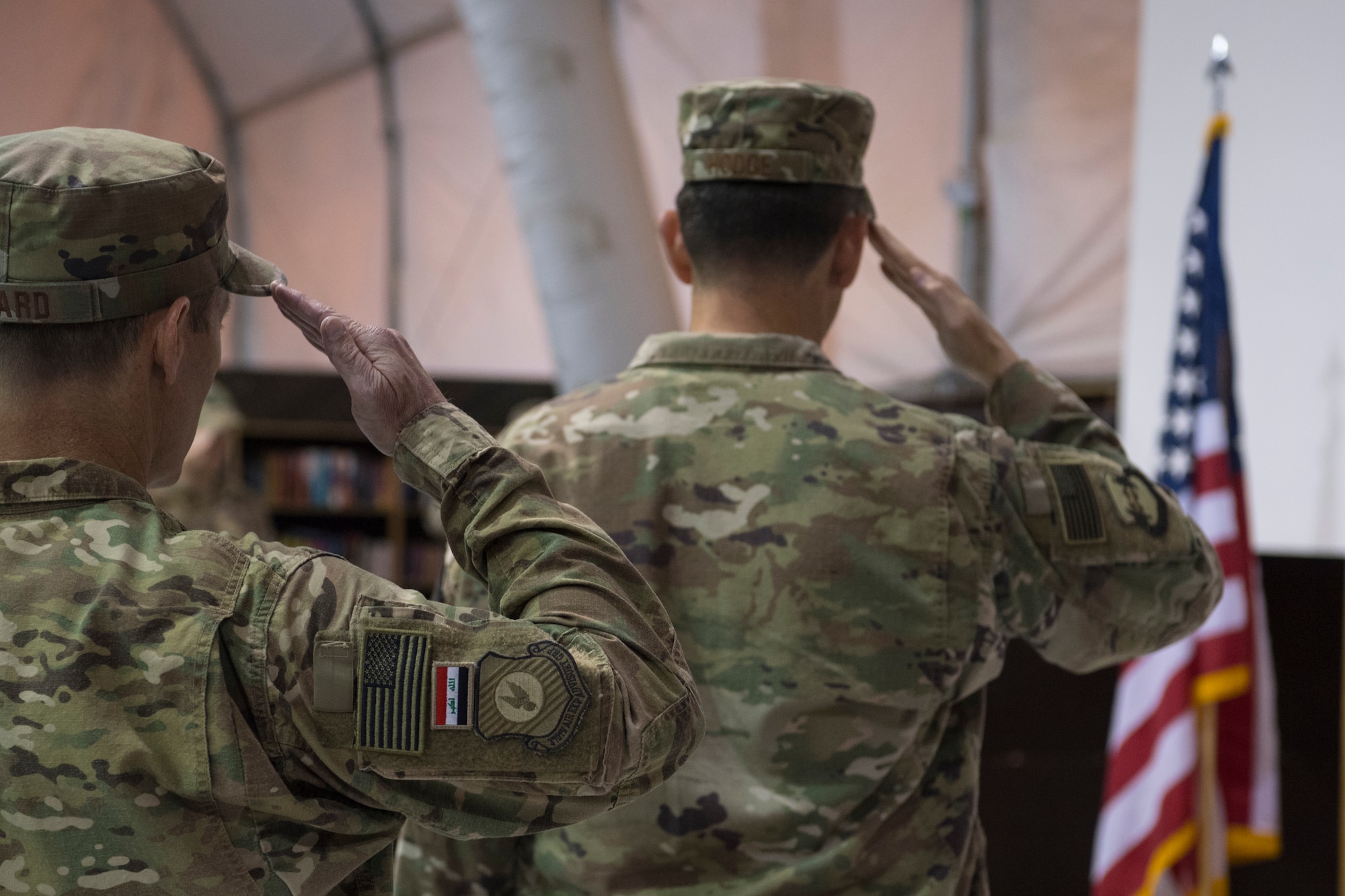 U.S. Air Force Col.’s James Howard, 370th Air Expeditionary Advisory Group commander, and Stephen Hodge, 386th Air Expeditionary Wing commander, salute the flag during the playing of the United States National Anthem, and Iraqi National Anthem May 26, 2018, in Baghdad, Iraq. Hodge presided over the relinquishment of command ceremony for Howard. (U.S. Air Force photo by Staff Sgt. Joshua King)