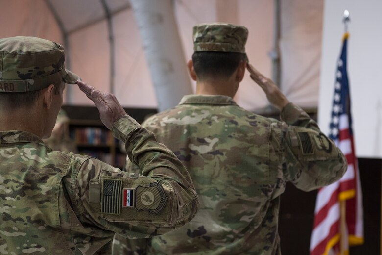 U.S. Air Force Col.’s James Howard, 370th Air Expeditionary Advisory Group commander, and Stephen Hodge, 386th Air Expeditionary Wing commander, salute the flag during the playing of the United States National Anthem, and Iraqi National Anthem May 26, 2018, in Baghdad, Iraq. Hodge presided over the relinquishment of command ceremony for Howard. (U.S. Air Force photo by Staff Sgt. Joshua King)