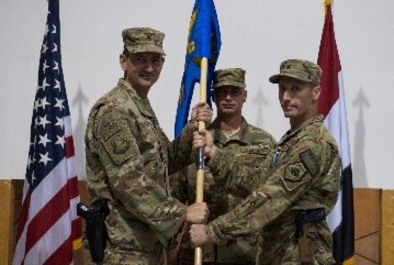 U.S. Air Force Col. James Howard, 370th Air Expeditionary Advisory Group commander, passes the 370th AEAG guidon to Col. Stephen Hodge, 386th Air Expeditionary Wing commander, signifying his relinquishment of command May 26, 2018, in Baghdad, Iraq. Passing of the guidon has been a part of military tradition since 1775 when General George Washington stood under an elm tree and assumed command of the Continental Army. (U.S. Air Force photo by Staff Sgt. Joshua King)