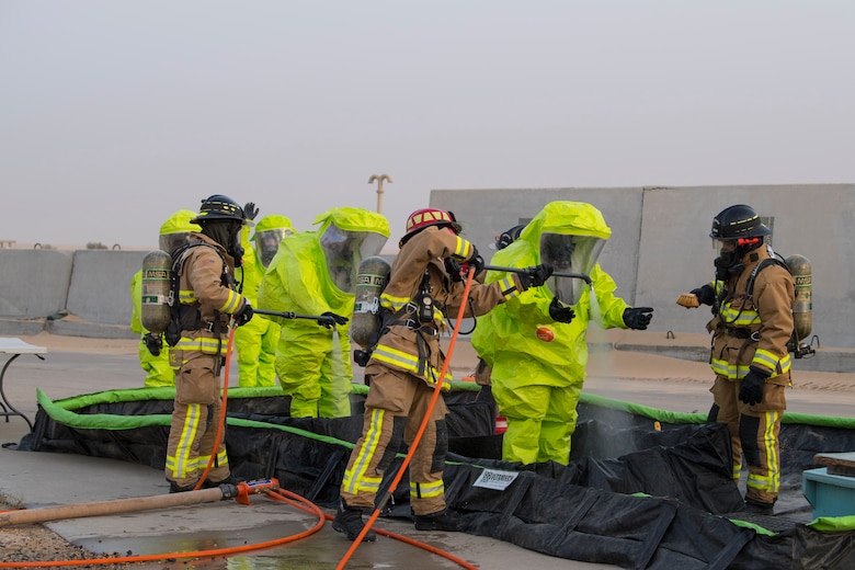 Airmen from the 386th Expeditionary Civil Engineer Squadron emergency management office are cleaned by 386th ECES fire fighters in a decontamination area after responding to hazardous materials at an undisclosed location in Southwest Asia, May 30, 2018. The team Spent just over an hour in their hazardous materials suits each day. (U.S. Air Force photo by Staff Sgt. Joshua King)
