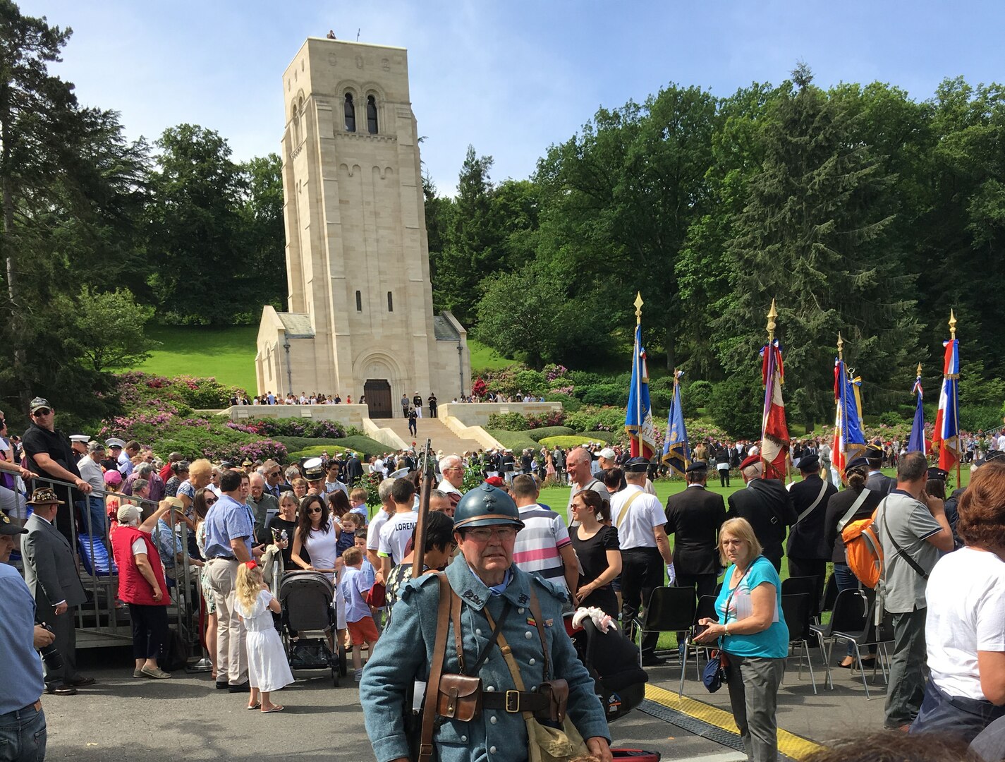 A reenactor joins attendees in honoring the sacrifices of Allied forces 100 years ago during the battles of Belleau Wood and Château-Thierry in France, near the end of World War I. In the background is the Aisne-Marne Memorial.