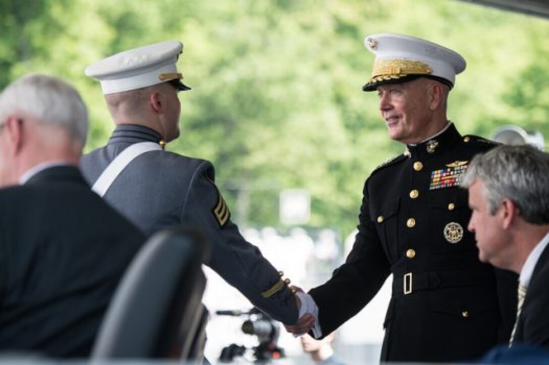Marine Corps Gen. Joe Dunford, chairman of the Joint Chiefs of Staff, shakes hands with a  U.S. Military Academy graduate.