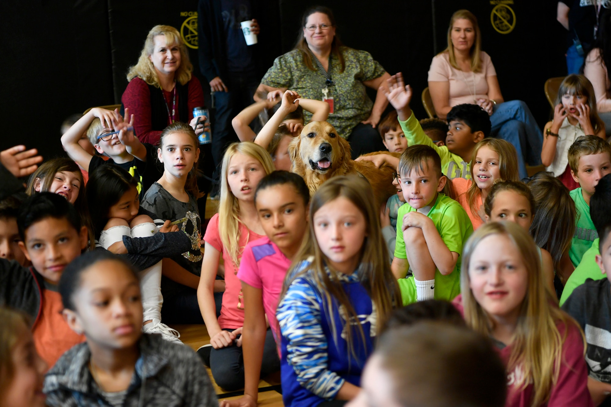 Children and dog listen to special guest speaker Col. Jack “2 Fish” Fischer, NASA astronaut, speak about his personal experiences in space exploration, May 22, 2018, at Aurora Quest K-8 School, Aurora, Colorado. The presentation was held during a general assembly and was a surprise to the nearly 600 students in attendance. (U.S. Air Force photo by Senior Airman Madison J. Ratley)
