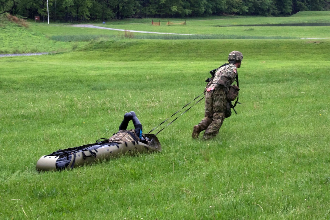 A soldier drags a dummy in a sked litter during the stress shoot exercise.