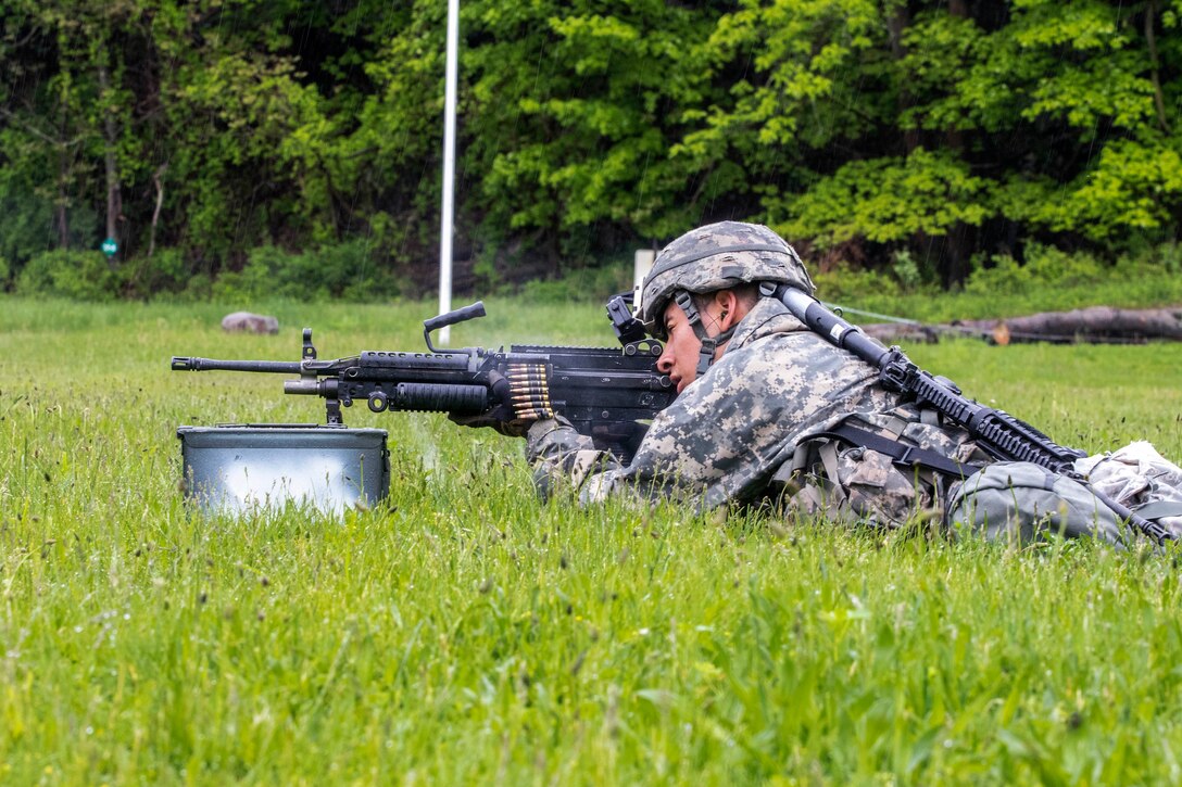 A soldier fires an M249 Squad automatic rifle while competing in the stress shoot event.