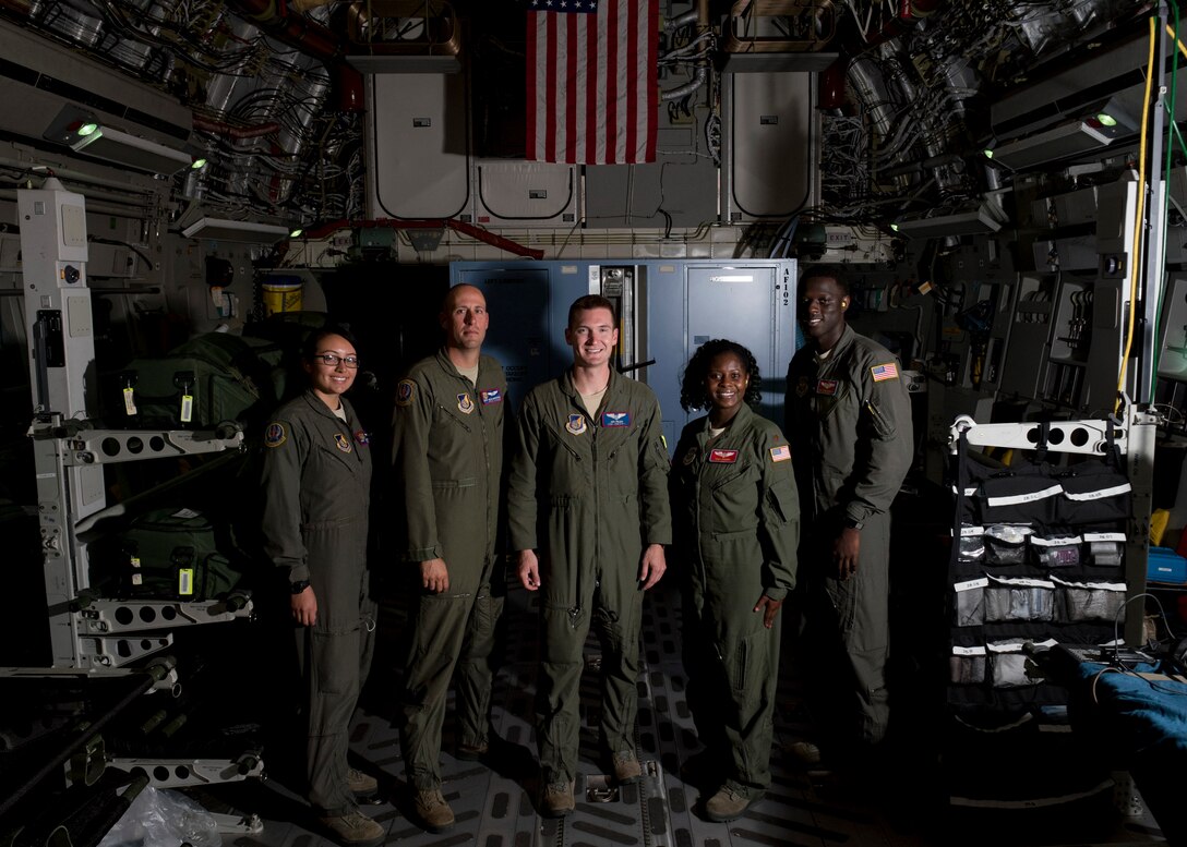 Airmen with the 375th Aeromedical Evacuation Squadron and 18th AES pause during a flight for a group photo on board a C-17 Globemaster III from Travis Air Force Base, Calif., May 14, 2018. The AE team along with a 21st Airlift Squadron C-17 aircrew and 860th Aircraft Maintenance Squadron flying crew chiefs departed Joint Base Pearl Harbor-Hickam, Hawaii, in support of the aerial transport of patients at various military bases in the Pacific. (U.S. Air Force photo by Lan Kim)