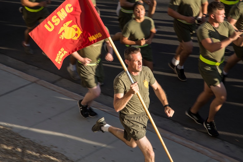 U.S. Marine Corps Maj. Jonathan D. Schaafsma, executive officer of Headquarters and Headquarters Squadron (H&HS), Marine Corps Air Station (MCAS) Yuma, Ariz., runs with the squadron guidon during a motivational run on MCAS Yuma, Ariz., May 25, 2018. H&HS conducted the motivational run to kick off the Memorial Day 96 hour liberty period, and to say farewell to Lt. Col. James S. Tanis. Lt. Col. Tanis served as the commanding officer of H&HS  for the past two years. (U.S. Marine Corps photo by Sgt. Allison Lotz)
