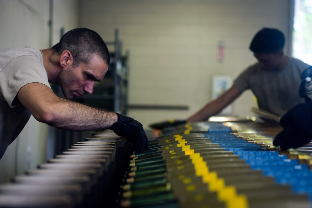 An officer inspects target practice rounds.