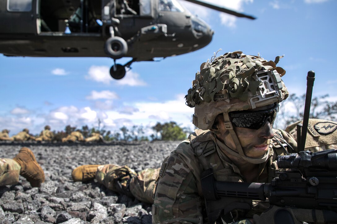 A soldier provides security while a helicopter takes off.
