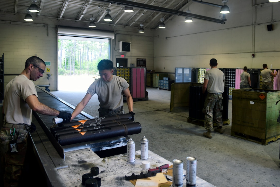 A technician processes high explosive and target practice rounds