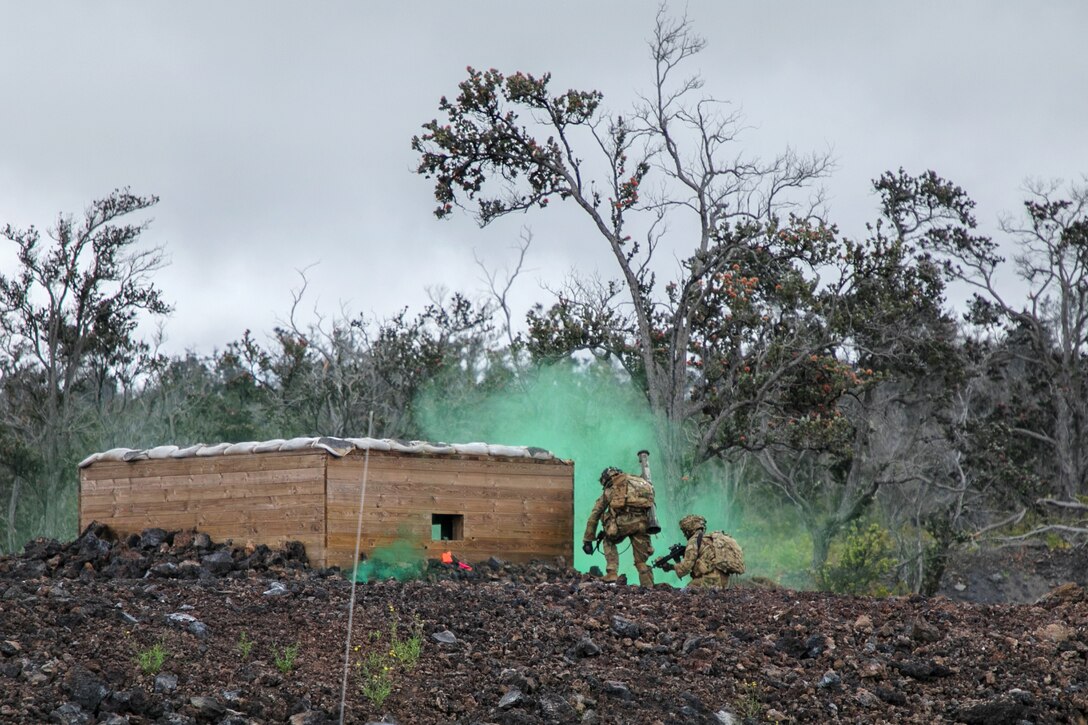 Soldiers clear a bunker under the cover of smoke.
