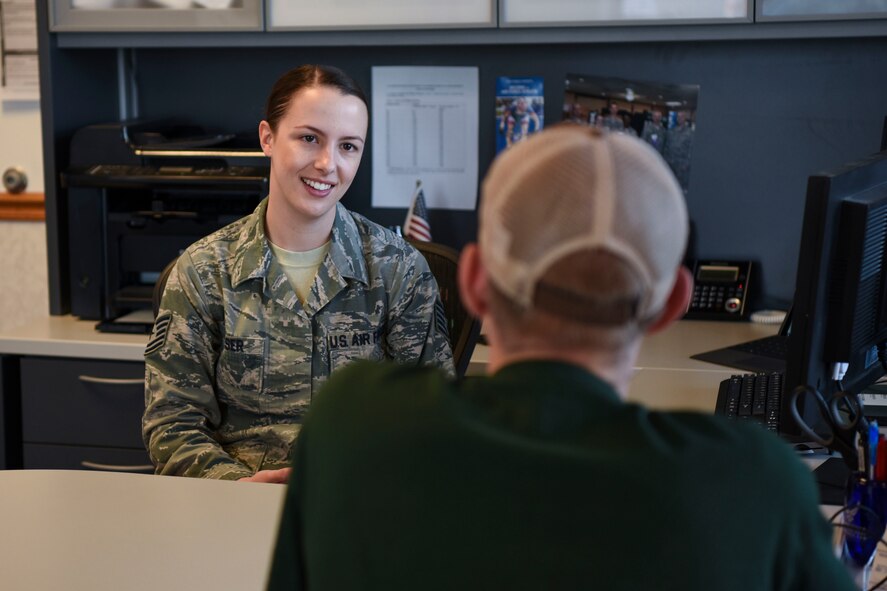 Air Force Tech. Sgt. Kimberly Reeser, recruiter located in Grand Forks, North Dakota, assists a recruit with the transition into the military here. Reeser said she feels a sense of accomplishment helping people become eligible to join the military. (U.S. Air Force photo by Airman 1st Class Melody K. Wolff)