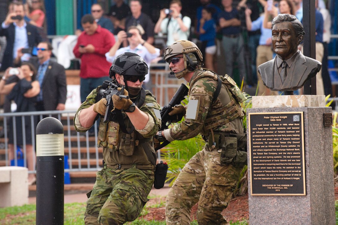 U.S. and multinational special operations forces maneuver around a statue.