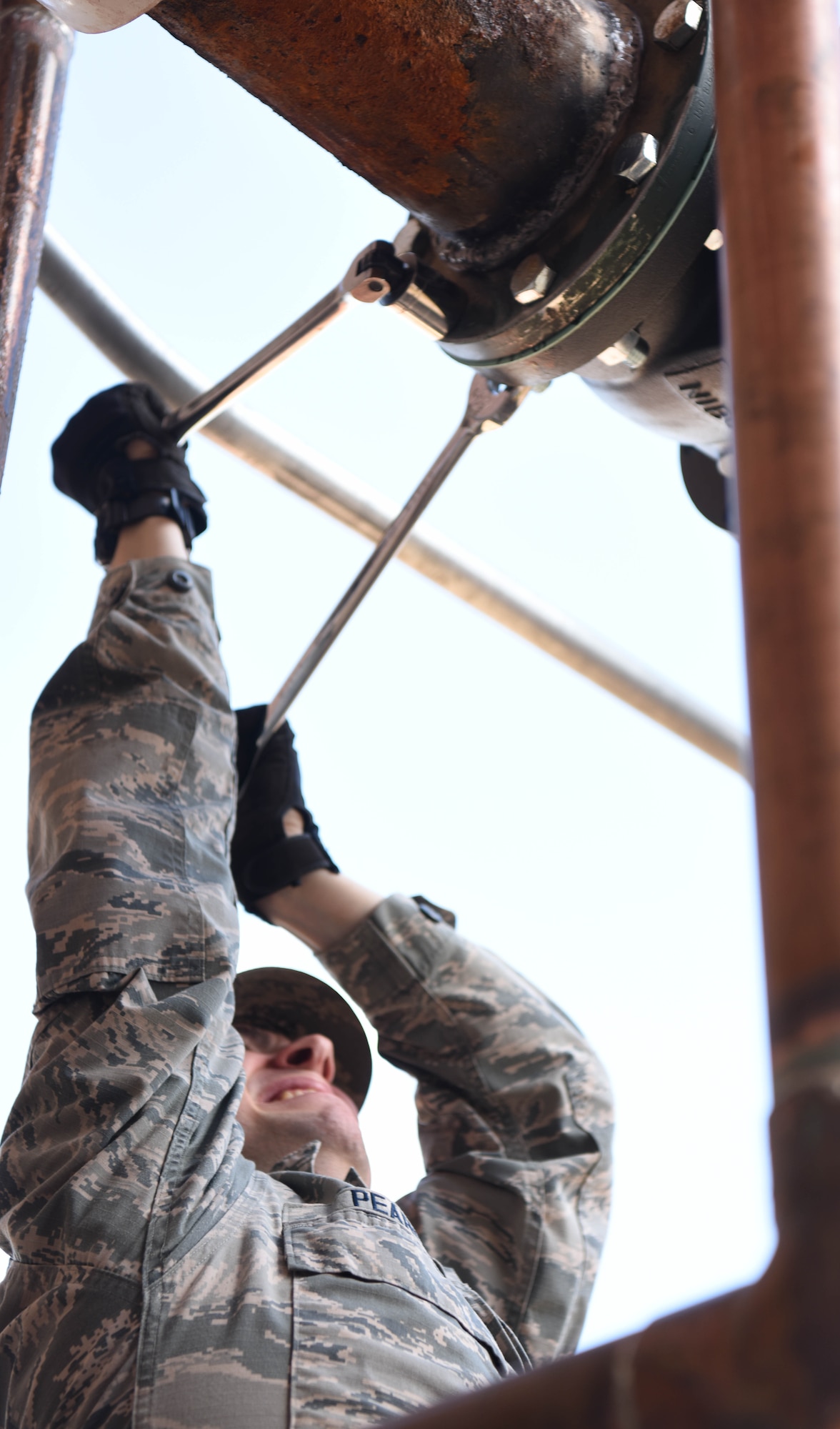 Airman 1st Class Christopher Pearce, a 28th Civil Engineer Squadron heating, ventilation and air conditioning apprentice, turns wrenches to loosen bolts on a pipe connected to an air conditioning unit at Ellsworth Air Force Base, S.D., May 3, 2018.  The 28th CES HVAC shop is responsible for installing and maintaining all of Ellsworth’s heating, cooling, ventilation and refrigeration equipment. (U.S. Air Force photo by Airman 1st Class Thomas Karol)