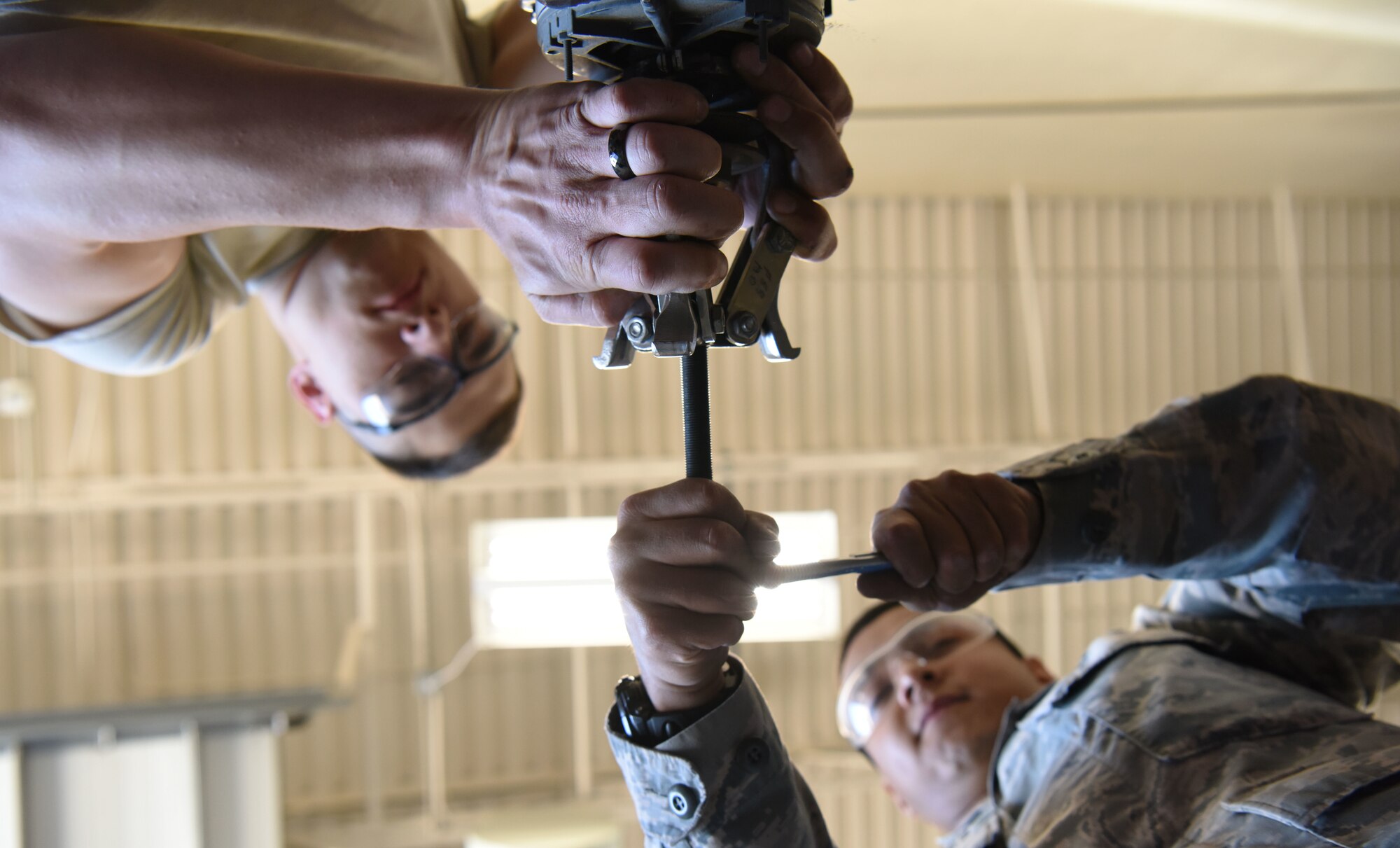 Senior Airman Julian Hernandez, a 28th Civil Engineer Squadron heating, ventilation and air conditioning journeyman, and Airman 1st Class Michael Schall, a 28th CES HVAC apprentice, use a vice grip and a wrench to fix a fan motor at Ellsworth Air Force Base, S.D., May 3, 2018. The 28th CES HVAC shop is responsible for installing and maintaining all of Ellsworth’s heating, cooling, ventilation and refrigeration equipment. (U.S. Air Force photo by Airman 1st Class Thomas Karol)