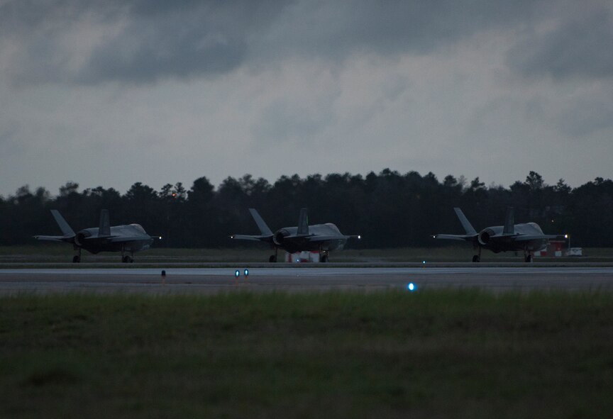 Three F-35A Lightning II's taxi down the runway May 30, 2018, at Eglin Air Force Base, Fla. The 33 FW conducted F-35A night flying operations May 29-31, 2018, satisfying a training requirement for student pilots who will routinely fly day and night operations upon entering the combat Air Force. During this iteration of the pilot training syllabus, the night flying portion was stretched later into evening hours than in the past, allowing for more qualifications to be checked off across fewer days. (U.S. Air Force photo by Staff Sgt. Peter Thompson)