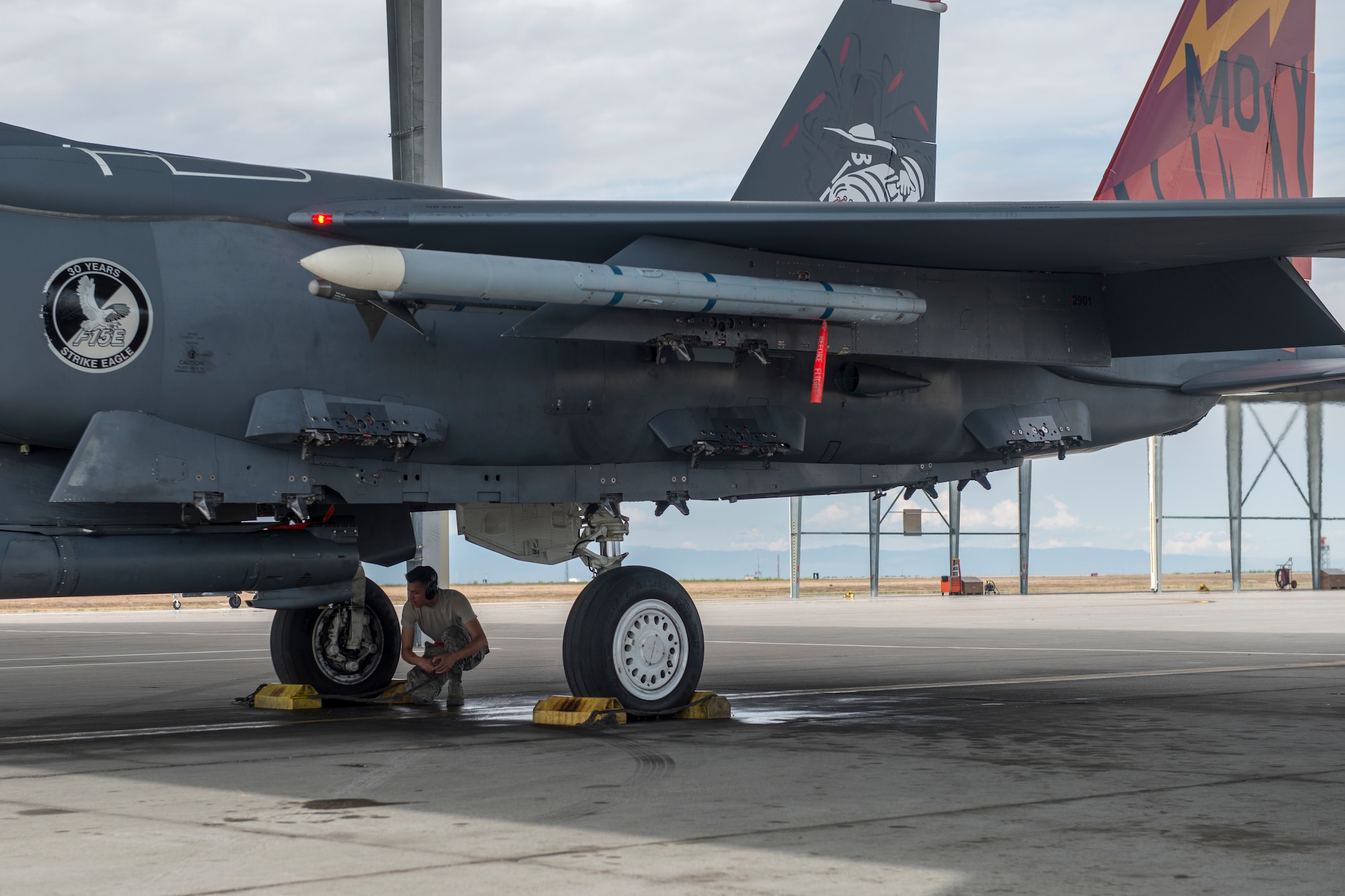 Airman 1st class Christian Gerardo, 366th Aircraft Maintenance Squadron weapons load crew member, pulls the chocks from an F-15E Strike Eagle during an exercise, May 22, 2018 at Mountain home Air Force Base, Idaho. Gunfighter Flag 18-2 encompassed both the Belgian Air Component and Idaho Civil Air Patrol. (U.S. Air Force photo by Airman 1st Class JaNae Capuno)