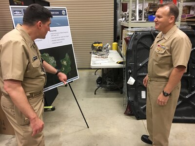 IMAGE: CMDR Steve Perchalski (left) discusses Naval Surface Warfare Center (NSWC) Dahlgren Division's directed energy facilties during NSWC Commander Rear Adm Thomas Anderson's visit, May 31. The admiral spent the day getting familiar with the division's portfolio of capabilities.