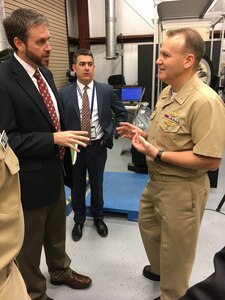 IMAGE: Dr. Chris Lloyd (left) of NSWCDD, discusses high-energy lasers with NSWC Commander Rear Adm. Thomas Anderson during his visit to Dahlgren Division, May 31. The admiral was touring the division to get acquainted with its programs and research areas.