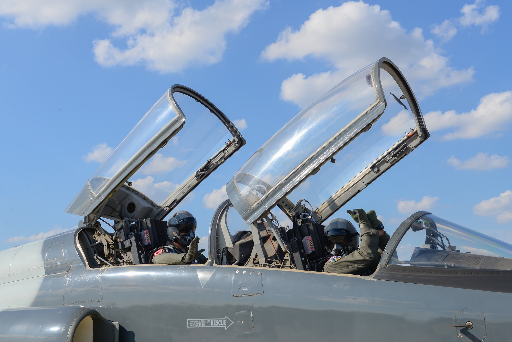 Second Lieutenant Colin Asbury, 47th Flying Training Wing pilot graduate, signals to pull chocks before one of his final training flights at Laughlin Air Force Base, Texas, May 15, 2018. After 52 weeks of Specialized Undergraduate Pilot Training, Asbury moves on to fly his aircraft of choice the F-15E Strike Eagle. The wings Asbury received upon graduation first entered service in 1941, and makes him the third carrier of this particular pair. (U.S. Air Force photo by Senior Airman Benjamin N. Valmoja)