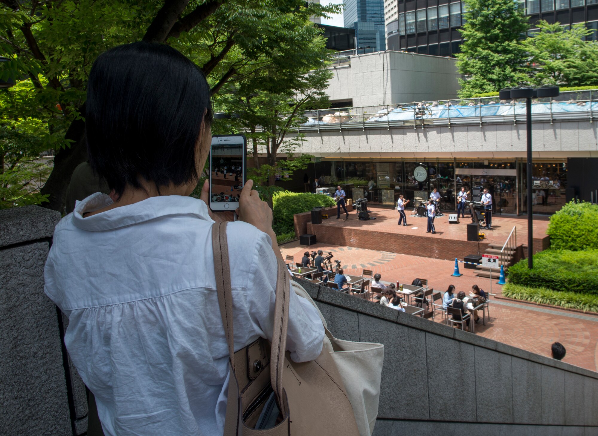 An audience member films the U.S. Air Force Band of the Pacific-Asia ensemble Final Approach