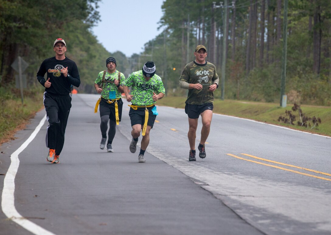 U.S. Marine Corps Lt. Col. Christopher Benfield, left, commanding officer of Headquarters and Headquarters Squadron (H&HS), runs with a group of Marines during the All Terrain Unit Competition on Marine Corps Air Station Cherry Point, North Carolina, Oct. 26, 2018. The All Terrain Unit Competition is an annual event hosted by Cherry Point Marine Corps Community Services for Marines and Sailors on station to build camaraderie through friendly competition. Service members faced multiple physical and mental challenges throughout a 6 mile course, including being chased by Marine volunteers acting as zombies, provided by the Single Marine Program. If a competitor had their flag stolen by a zombie, time would be added to their team’s overall finishing time.  (U.S. Marine Corps photo by Cpl. Micha R. Pierce)